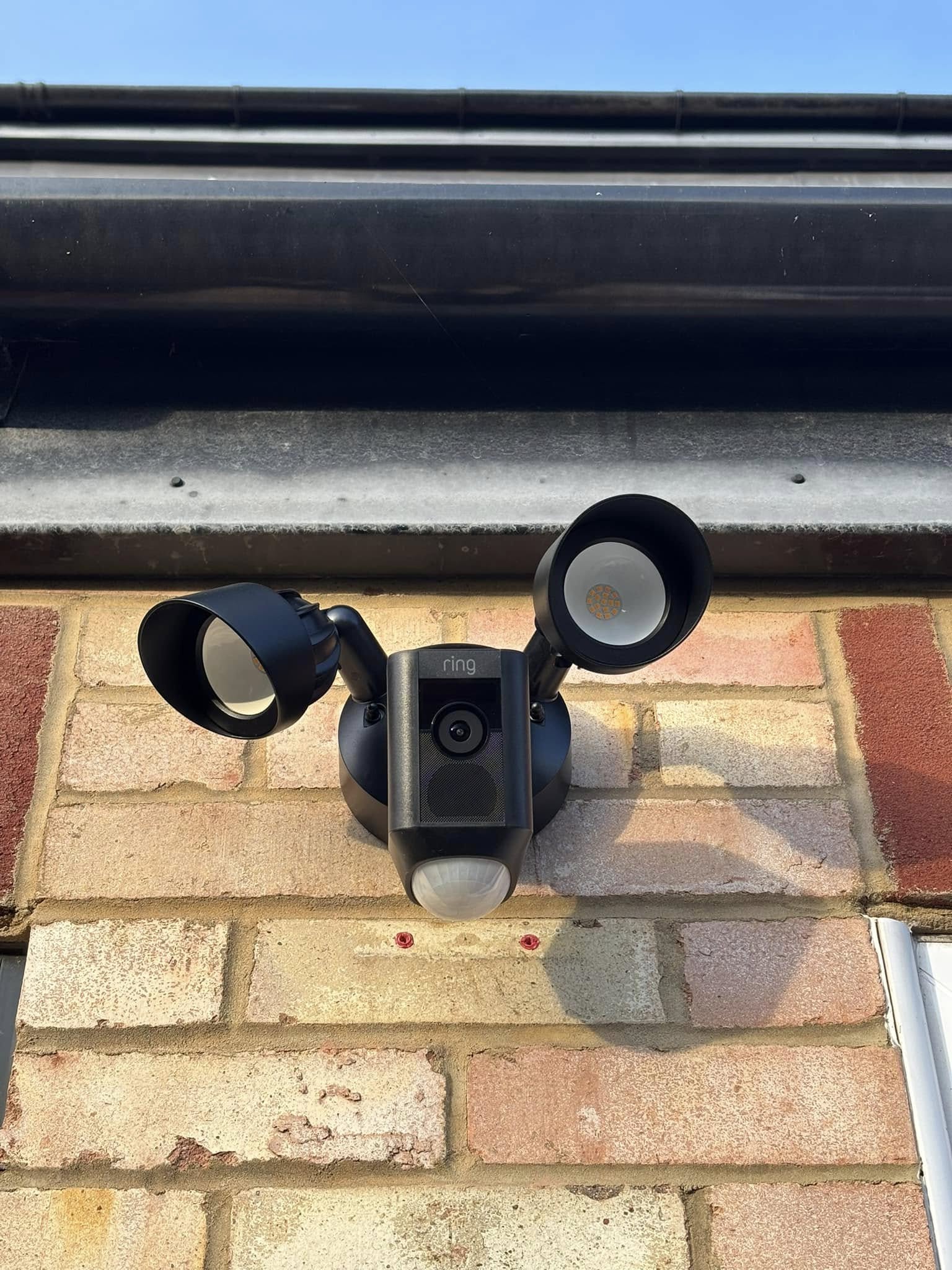 Ring floodlight security camera installed on exterior brickwork