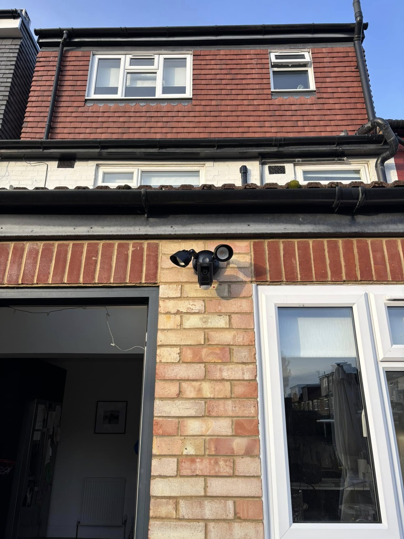 Ring floodlight security camera installed above a doorway
