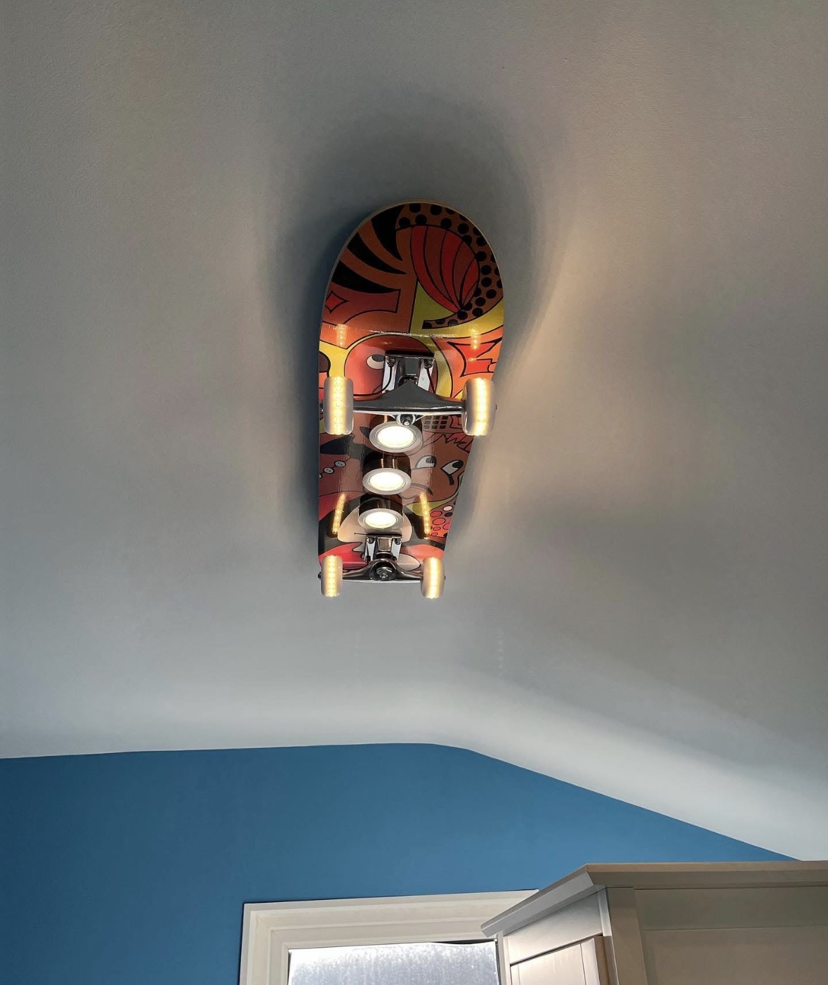 Custom skateboard-shaped ceiling light fixture installed in a children's bedroom